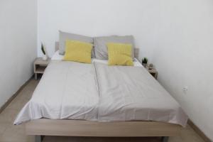 a bedroom with a large bed with yellow pillows at Apartments Andrea in Vela Luka