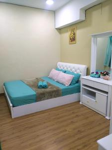 a small bedroom with a bed and a dresser at Ayu Homestay DPerdana Apartment in Kota Bharu