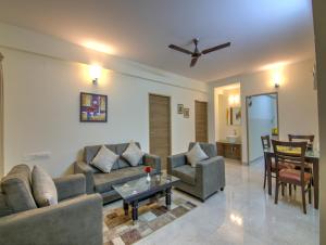 una sala de estar con un sofá y una mesa en Sunshine Suites Grand Deluxe, en Bangalore