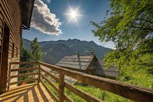 a wooden balcony of a house with a view of mountains at Le Grand Tetras in Saint-Véran