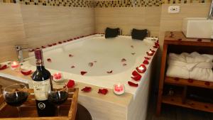 a bath tub filled with red roses and a bottle of wine at Fontana Plaza Hotel in Villa de Leyva