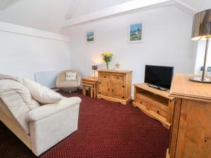 
a living room filled with furniture and a tv at The Stables in Penzance
