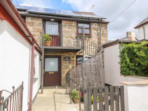 a brick house with a staircase leading to the front door at The Stables in Penzance