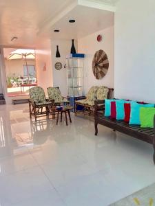 a living room with a couch and chairs and a table at Pousada Bella Boipeba in Ilha de Boipeba