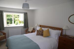 a bedroom with a bed with pillows and a window at Low Raisgill B&B in Buckden