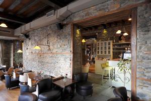 a restaurant with stone walls and tables and chairs at Marelia Hotel in Polygryos