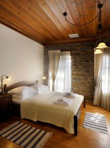 ポリギロスにあるMarelia Hotelの大きなベッドと木製の天井のある寝室