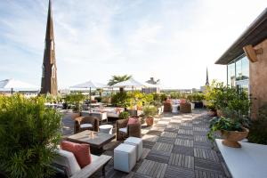 a rooftop patio with tables and chairs on a building at The Dewberry Charleston in Charleston