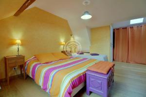 a bedroom with a large bed with a colorful blanket at La Boucle de l'Adour Chambres d'Hôtes & gîtes in Campan