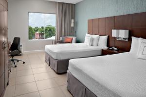 
a hotel room with a bed, desk, and chair at Courtyard by Marriott Bridgetown, Barbados in Bridgetown
