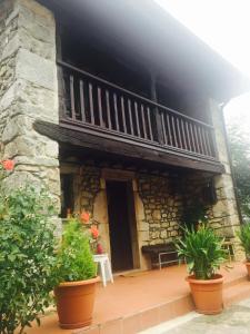 una casa con balcone e alcune piante di Flor de Pomar a Corao