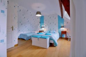 a bedroom with a bed with blue sheets and blue walls at La Boucle de l'Adour Chambres d'Hôtes & gîtes in Campan