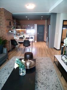 a living room with a table and chairs and a kitchen at Luxury Stay Rosebank Johannesburg in Johannesburg