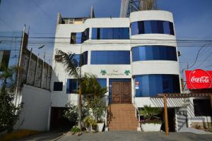 a white building with blue windows and a door at Qallwa Asia in Asia