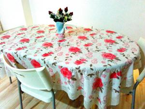 a table with a table cloth with a vase of flowers on it at Happy Sweet Residence in Melaka