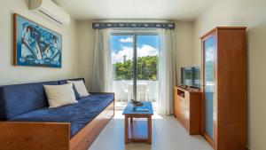 a living room with a blue couch and a window at Acorsonho Apartamentos Turisticos in Capelas +28 photos