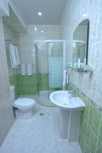 a bathroom with a sink and a toilet and a shower at VIARDO Hotel in Tashkent