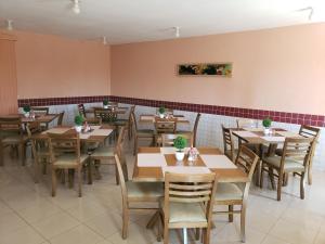 a restaurant dining room with wooden tables and chairs at Alvimar Hotel in Sobradinho