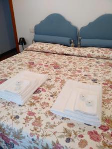 a bed with two white towels sitting on top of it at Tuttomondo in Pisa
