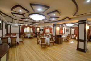 a restaurant with tables and chairs in a room at VIARDO Hotel in Tashkent