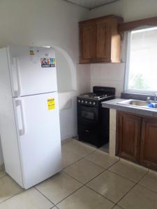 uma cozinha com um frigorífico branco e um fogão em CASA MARLE em Boquete