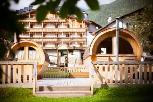 una terraza de madera con un edificio en el fondo en Hotel Posta, en Forni di Sopra