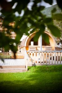 a white fence in front of a building at Hotel Posta in Forni di Sopra