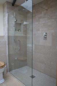 a shower with a glass door in a bathroom at Vineyard Barn Room in Woodchester +18 photos