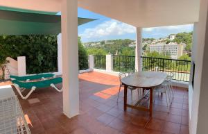 a patio with a table and chairs on a balcony at Es Cucó in Cala Galdana