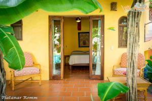 a yellow house with two chairs and a table at Casa Villa Magnolia B&B in Cruz de Huanacaxtle