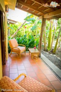 a porch with chairs and a coffee table on it at Casa Villa Magnolia B&B in Cruz de Huanacaxtle