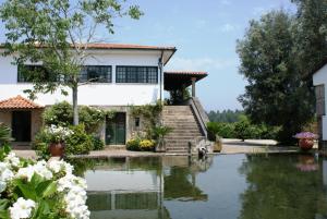 a house with a pond in front of it at Quinta Do Sobreiro in Vila Verde