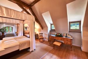 a bedroom with a canopy bed and a desk at Schloss Englar in Appiano sulla Strada del Vino
