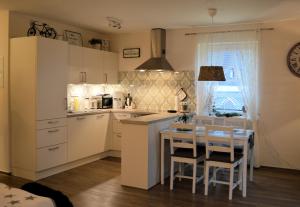 a kitchen with white cabinets and a table with chairs at Ferienwohnung Nitsche in Bad Laasphe +7 photos