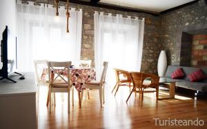 uma sala de estar com uma mesa de jantar e cadeiras em Apartamento Llerandi 1C - Ideal para dos personas em San Vicente de la Barquera