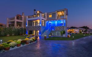 a large house with a blue glow in the night at Villa Shameti - Your Secluded Bliss in Zakynthos Town