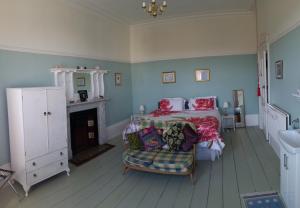 a bedroom with a bed and a chair and a sink at Grantham House in Ryde