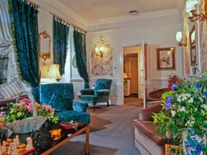Rosemullion Hotel في فالموث: غرفة معيشة مع كراسي زرقاء وأريكة