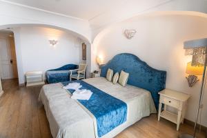 a bedroom with a large bed with a blue headboard at Covo dei Saraceni in Polignano a Mare