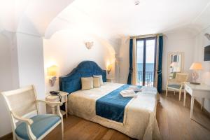 1 dormitorio con 1 cama, mesa y sillas en Covo dei Saraceni, en Polignano a Mare