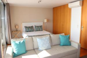 a white bed with pillows and pillows in a room at Bartolomeu Beach Apartments in Porto