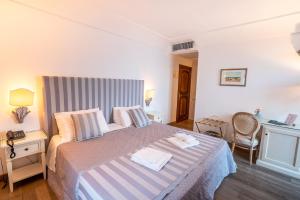 a bedroom with a large bed with a striped headboard at Covo dei Saraceni in Polignano a Mare