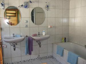ein Badezimmer mit zwei Waschbecken, einer Badewanne und einem Spiegel in der Unterkunft Ferienhaus Habitat Wonnegau in Flörsheim-Dalsheim