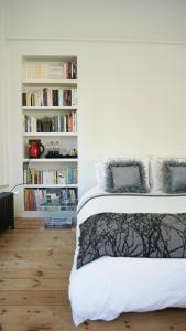 - une chambre avec un lit et une étagère avec des livres dans l'établissement Au Cœur De Lille, à Lille