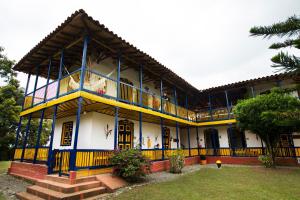a building with yellow and blue trim at Hotel Hacienda Combia in Armenia
