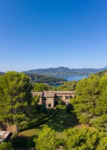a house on a hill with trees and a lake at Case Danesi in Rio nellʼElba