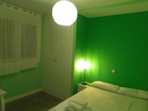 
a bedroom with a bed and a lamp at Hostal Consejo de Aranda in Aranda de Duero
