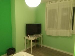 
a small room with a tv and a chair at Hostal Consejo de Aranda in Aranda de Duero
