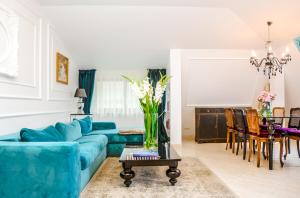 ein Wohnzimmer mit einem blauen Sofa und einem Tisch in der Unterkunft Medziotoju Apartments in Palanga