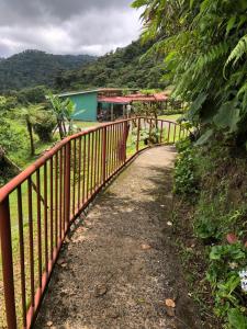 a red fence next to a dirt road at Vistaverde Lodge in Monteverde Costa Rica